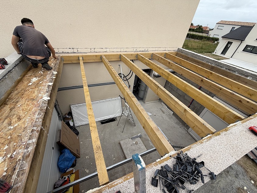 Réalisation d’une charpente en bois par Pister Rénovation en Loire-Atlantique : pose de poutres porteuses et renforcement de la structure pour garantir la solidité et la durabilité de la toiture.